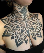 Dotwork mandala tatuering på bröstet.  Tjej tatuering.